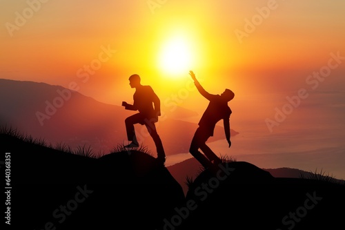 Silhouette hikers climbing on mountain on sunset background