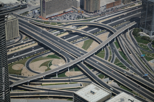 An aerial view of a stack interchange in Dubai. Freeways, onramps and offramps flow past, over, and under one another in an example of grade separation in road planning.