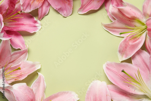 Frame made of beautiful lily flowers on green background