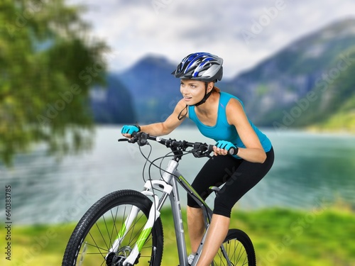 Fit sporty female cyclist riding on the road