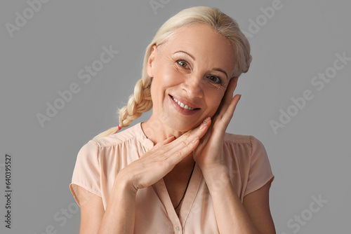 Mature woman on grey backgr...