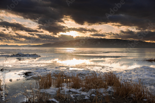 winter mountains across a lake at sunset