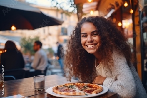 Girl eats pizza in street cafe