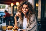 Girl eats burger on street cafe