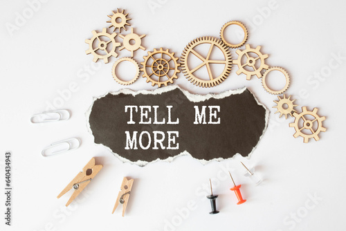Tell me more symbol. Concept words Tell me more on wooden notebook. Beautiful wooden background.