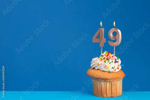 pink birthday candle - cupcake on blue base and blue background