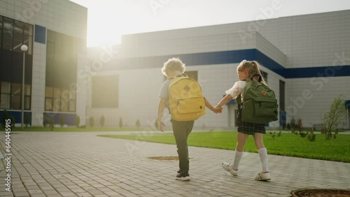 Pair Of School Children Going To School Together In Sunny Morning, First-Graders With Backpacks