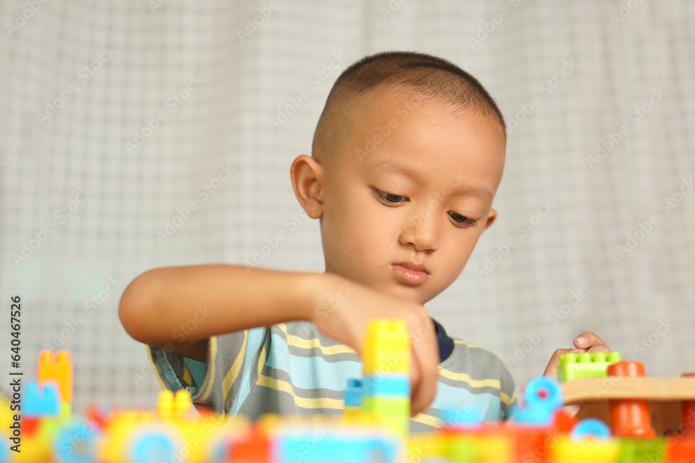Asian boy playing with educational toys There are many beautiful colors on the table in the house. Asian boy playing with educational toys There are many beautiful colors on the table in the house.