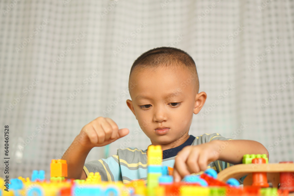 Asian boy playing with educational toys There are many beautiful colors on the table in the house. Asian boy playing with educational toys There are many beautiful colors on the table in the house.