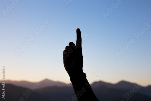 silhouette of hands in the shape of a number one with a beautiful colorful late afternoon sky in Rio de Janeiro.