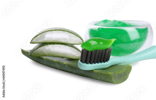 Brush with toothpaste and green aloe leaves on white background