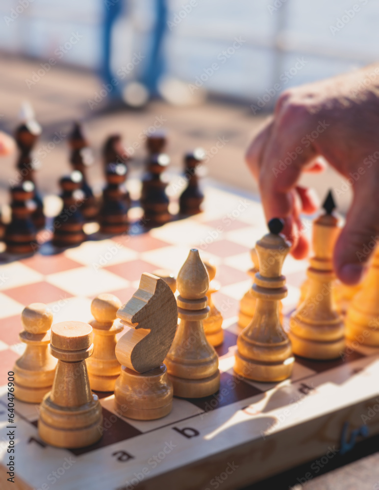 Chess tournament, kids and adults participate in chess match game outdoors in a summer sunny day, players of all ages play, competition in chess school club with chessboards on a table Chess tournament, kids and adults participate in chess match game outdoors in a summer sunny day, players of all ages play, competition in chess school club with chessboards on a table