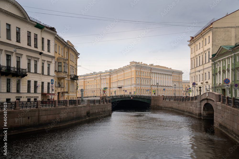Moika River embankment and view of the east wing of the General Staff Building on a summer day with clouds, St. Petersburg, Russia