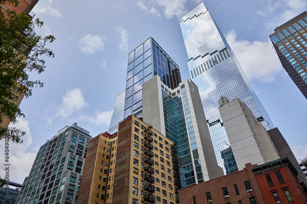 Tall and colorful buildings viewed from a low angle in the middle of New York City on a beautiful summer day