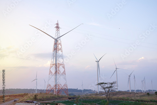 Windmill turbine farm for electricity generation on landscape mountain at sunset sky, Green power industry resouces, Sustainable and clean energy generator from wind and frieldly with enviroement photo