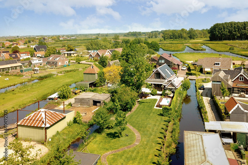 an aerial view of some houses in the country side with water running through them and trees growing on both sides