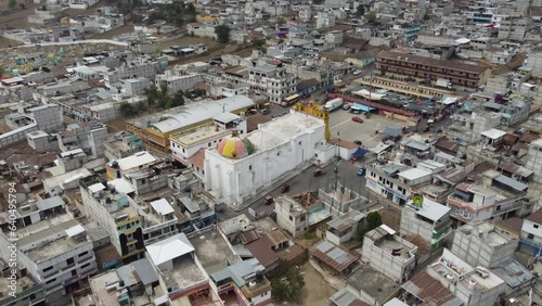 Aerial pulls out: Yellow Mayan Church in San Andres Xecul, Guatemala photo