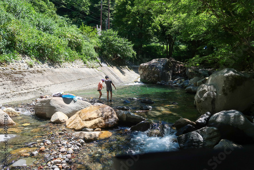 夏の渓流で水遊びをする子どもたち