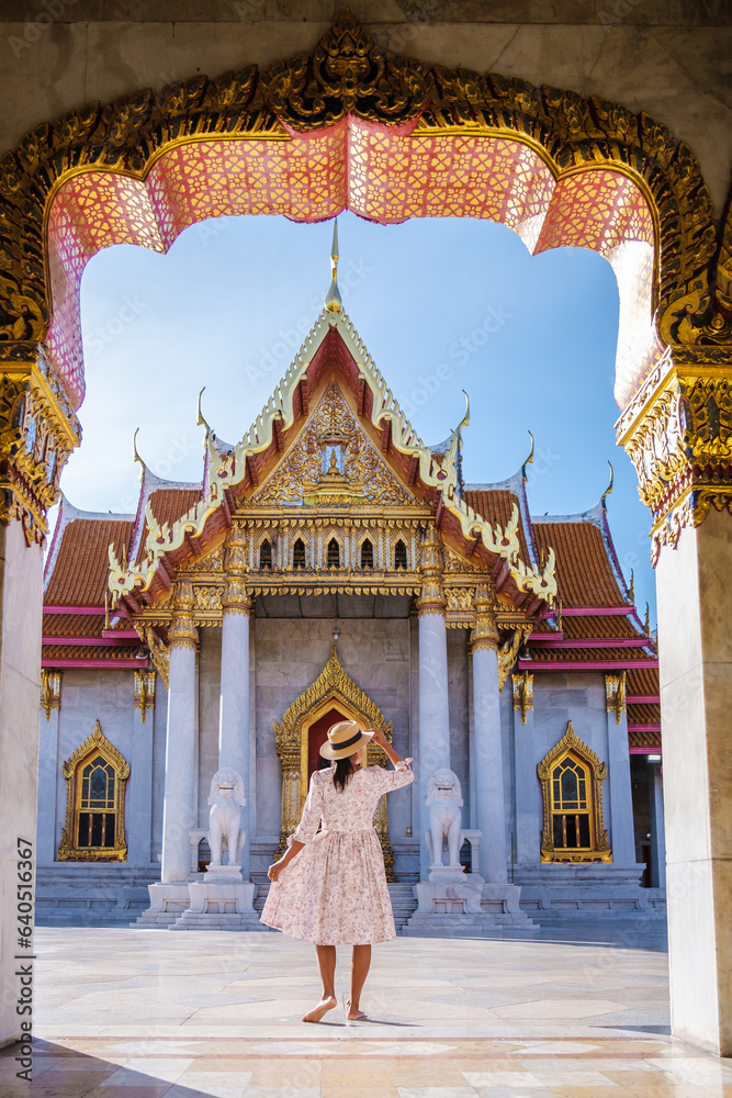 Obraz premium Wat Benchamabophit temple in Bangkok Thailand, The Marble temple in Bangkok. Asian woman with a hat visiting a temple, a women on a city trip in Bangkok