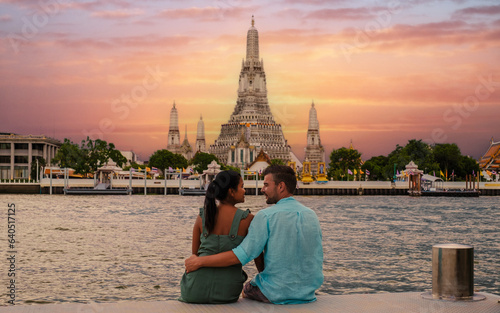 Wat Arun Temple Bangkok during sunset in Thailand. Chao Praya River at sunset. a couple of men and woman are on a city trip to Bangkok Thailand © Fokke Baarssen