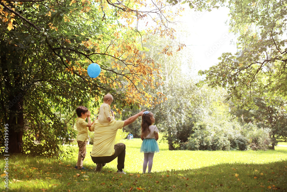 Fototapeta premium Family with children for a walk in the summer park. Сoming autumn in the park. Family. Fall. Happiness.