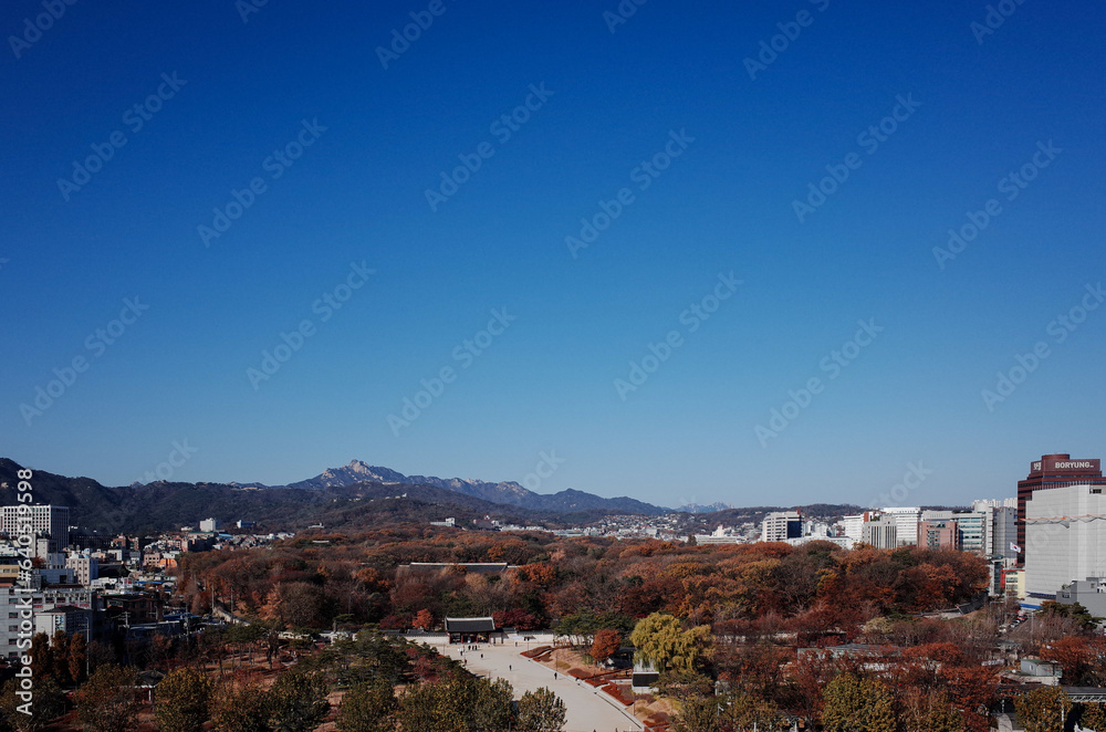 Obraz premium 푸른 하늘이 펼쳐진 서울 옥상에서 본 가을 산과 문화 유산 풍경