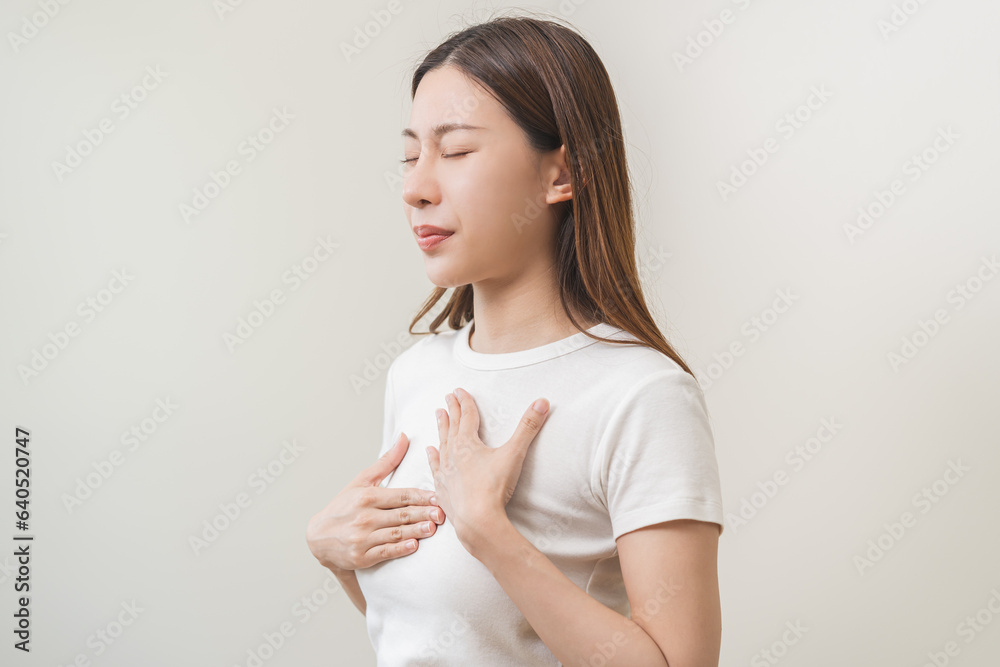 Obraz premium Acid reflux disease, suffer asian young woman have symptom gastroesophageal, esophageal, stomach ache and heartburn pain hand on chest from digestion problem after eat food, Healthcare medical concept