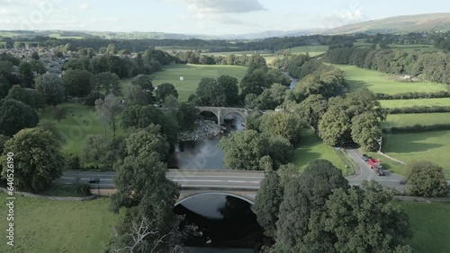 An aerial view of the Devil's Bridge at Kirkby Lonsdale on a summer evening, Yorkshire, England, UK. Flying towards the bridge from the southerly side with the A65 in the foreground. photo