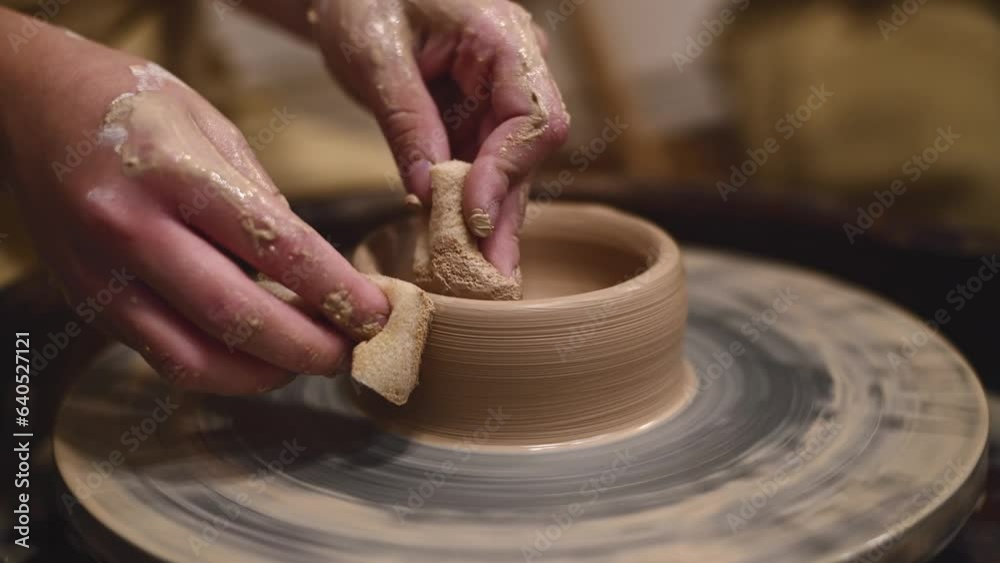 Potter girl works on potter's wheel, making ceramic pot out of clay in pottery workshop. Art and hobby concept Potter girl works on potter's wheel, making ceramic pot out of clay in pottery workshop. Art and hobby concept