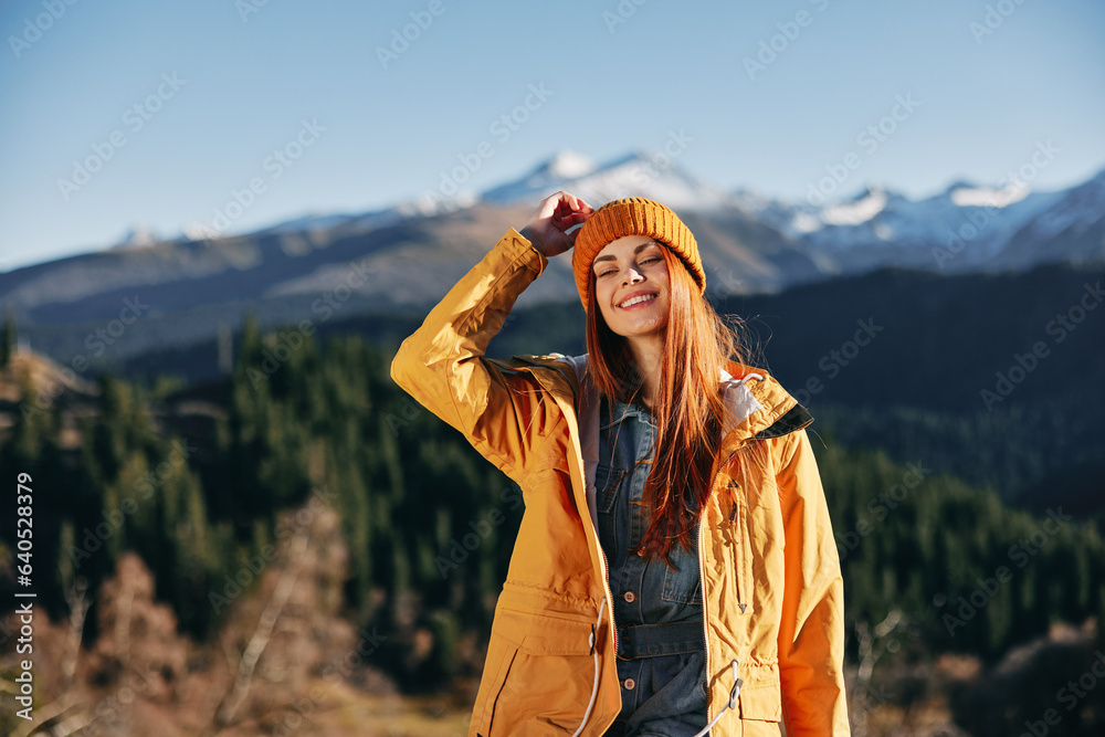 Woman hiking in the mountains in the fall with a smile with teeth and ...