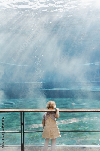 Little girl alone in an empty aquarium, aquarium in Genoa, Italy