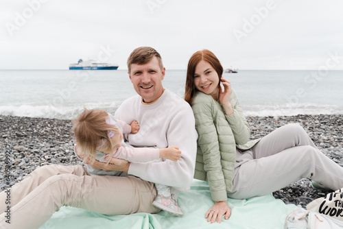 Happy family with a child of 2 years old on the seashore have a rest