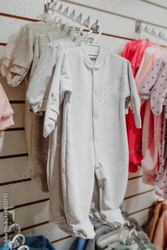 Baby overalls hang on a hanger in a children's clothing store. Baby Clothing © Katsiaryna