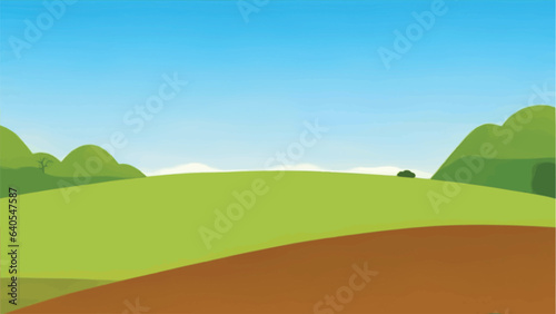 A green field hills in the background