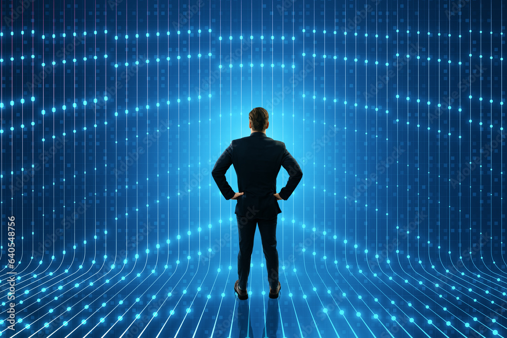 Back view of young businessman standing in creative futuristic blue neon room interior. Tunnel or corridor, glowing panels, fashion podium, performance stage decorations concept. Back view of young businessman standing in creative futuristic blue neon room interior. Tunnel or corridor, glowing panels, fashion podium, performance stage decorations concept.