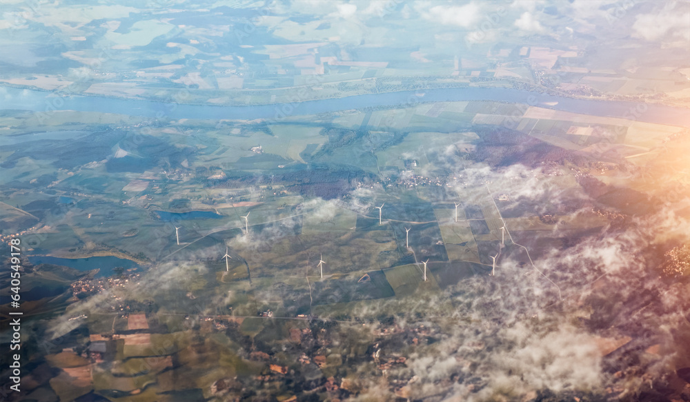 Aerial view of windmills. Harvesting Green Energy. Wind Turbines Amidst a Summer landscape. Renewable Energy Generation. Aerial View of Wind Turbines