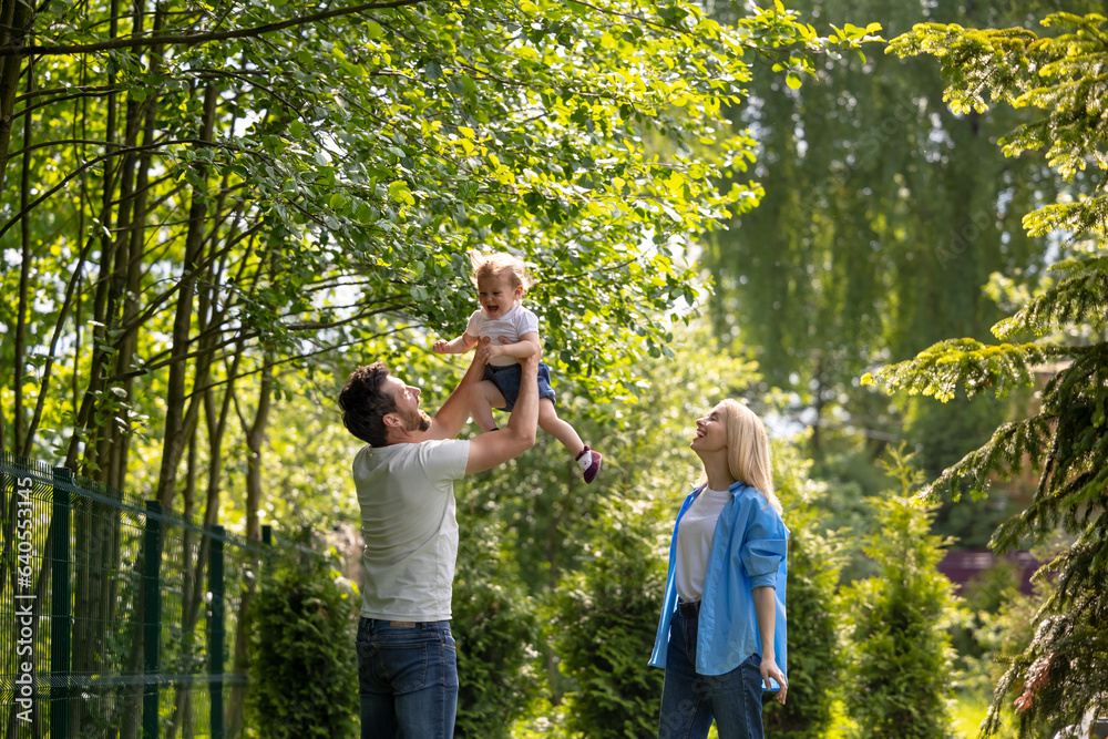 Fototapeta premium Happy young dad playing with his son and looking contented