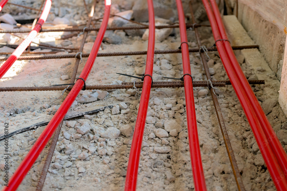 Laying special radial pipes for underfloor heating on the concrete floor of a building under construction