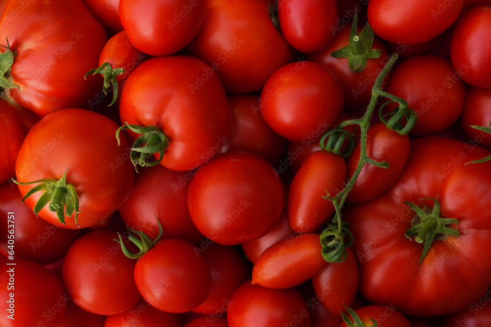 Tomatoes lying on a pile on top of each other, tomato texture. Selective focus. Top view.