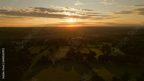 Establishing Drone Shot into the Sun Over Grass Fields at Golden Hour Sunrise photo