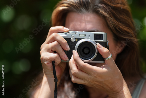 Close-up of a woman taking photos outdoors. Travel and photography concept.