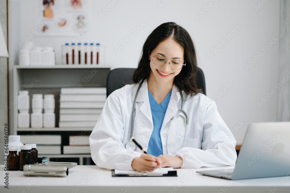 Beautiful physician doctor sit on table in office hospital. Attractive therapist female practitioner pharmacist smile and use tablet and laptop. after success work from treatment Beautiful physician doctor sit on table in office hospital. Attractive therapist female practitioner pharmacist smile and use tablet and laptop. after success work from treatment