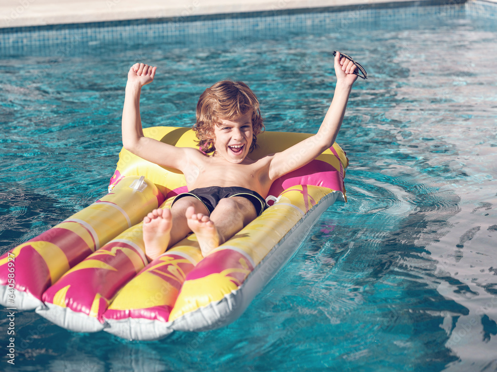 Cheerful boy relaxing on inflatable float
