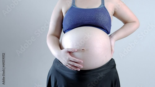 Pregnant woman holding belly with hands