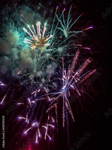 Multi-colored fireworks, sparks and smoke flash in the sky during a holiday in the evening	
 photo