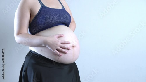 Pregnant woman holding belly with hands