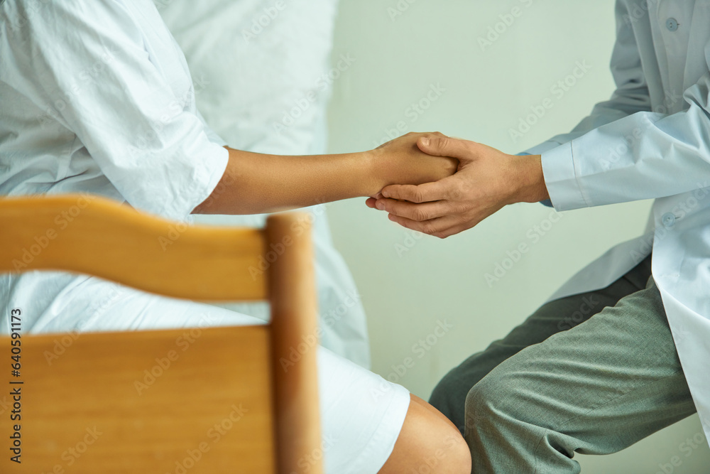 cropped view of doctor holding hands of african american woman, private ward, hospital patient cropped view of doctor holding hands of african american woman, private ward, hospital patient