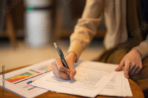 Asian woman executive thoroughly analyzes, remotely approves investment for strategic company growth