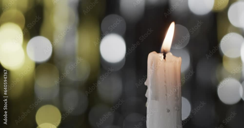 Video of white candle with white flame and copy space with bokeh on black background