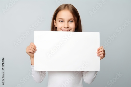 Happy Scholl girl holding blank white banner sign, isolated studio portrait.